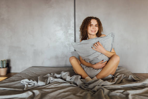 istock Young woman hugging pillow on comfortable bed 1475488714