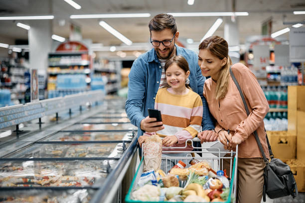 istock Happy family using mobile phone while shopping in supermarket. 1475489470