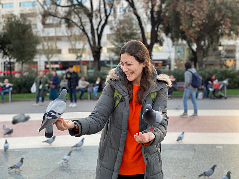 Laughing Woman Feeding Pigeons in The Street. Travel around Europe, Barcelona