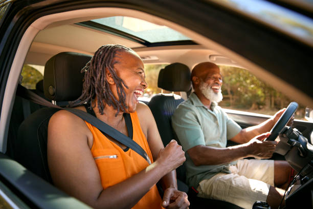 Coppia senior che si gode la gita di un giorno d'estate fuori guidando in auto insieme - foto stock