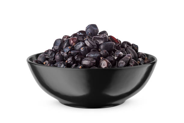 istock Black dried barberry in black bowl isolated on white. Front view. 1475490395
