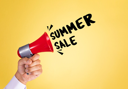 Hand holding megaphone with text summer sale