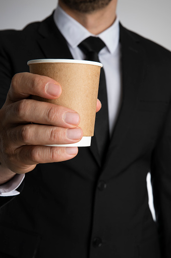 Businessman is holding paper cup