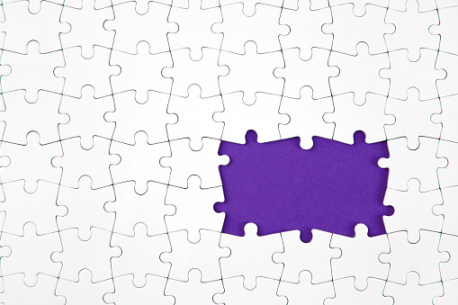 incomplete white puzzle pieces on purple background