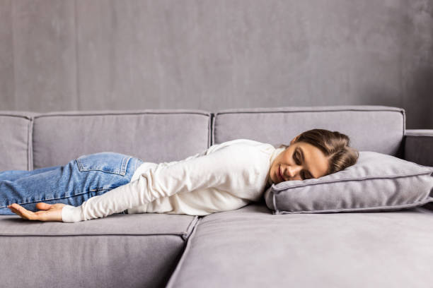 istock Young woman sleeping on sofa at home 1475496773