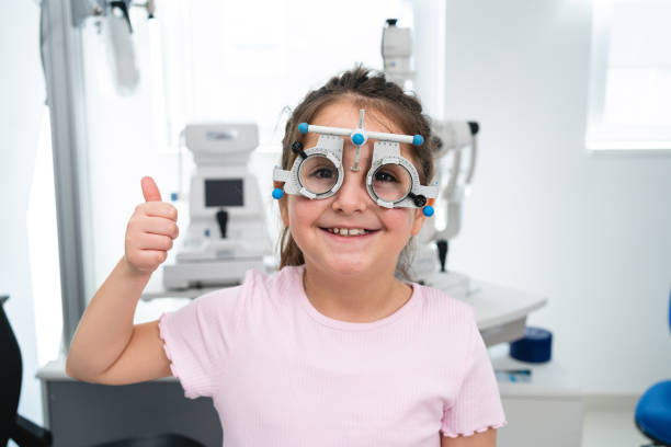 istock Girl showing thumb up while wearing trial frame used for eyesight tests, at the ophthalmology clinic 1475496868