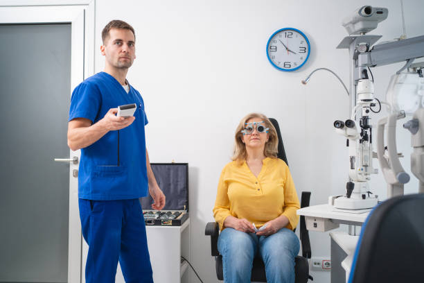 istock Male ophthalmologist, examining senior female patient eyesight, while using trial frame and different lenses 1475496913