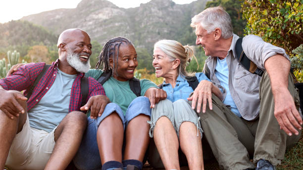 istock Active Senior Friends Sitting Taking A Break Hiking Through Countryside Together 1475497169