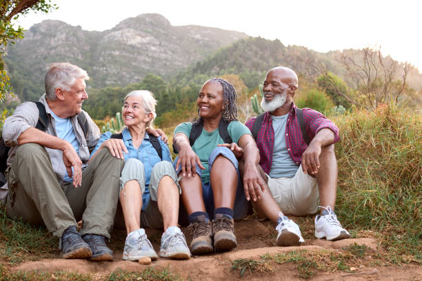 istock Active Senior Friends Sitting Taking A Break Hiking Through Countryside Together 1475497624