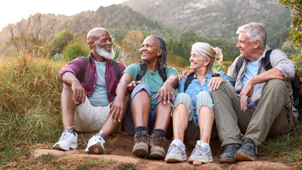 istock Active Senior Friends Sitting Taking A Break Hiking Through Countryside Together 1475498493