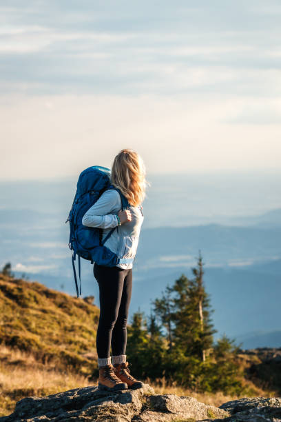 istock Woman with backpack hiking in mountains 1475501131