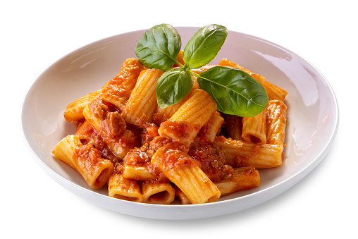 Macaroni rigatoni with tomato sauce and meat in white dish with basil leaves, isolated on white, clipping path