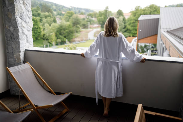 istock Woman in bathrobe enjoying beautiful view from hotel balcony 1475501410
