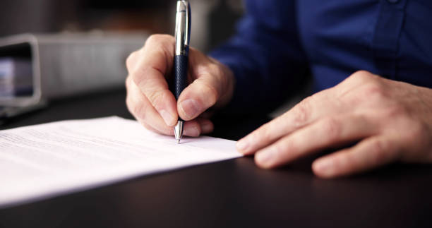 istock Businessman Holding Pen To Sign 1475501469
