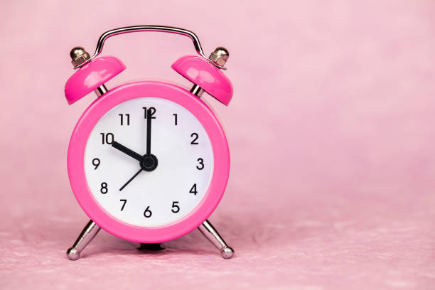 istock Retro alarm clock on pink background, daylight savings time 1475502715