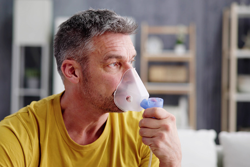 Asthma Patient Breathing Using Oxygen Mask And COPD Nebulizer