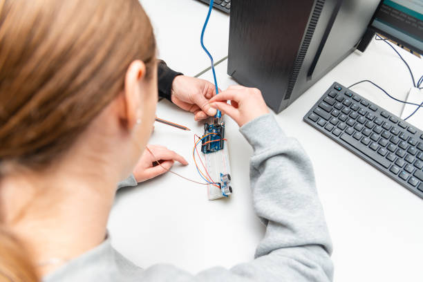 istock Science Lesson.Student girl and teacher.Stem projects and mini engineering projects building components.classroom indoors,back view. 1475505170