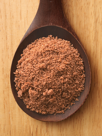 Top view of wooden spoon with chocolate cake crumbs on it