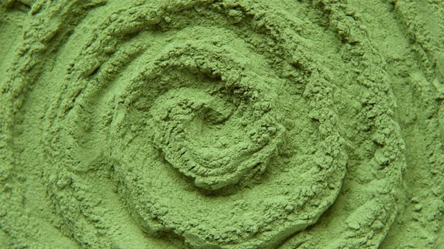 Chlorella or spirulina algae green powder is spinning, rotation. Dietary supplement to improve health. Seaweed superfood. Healthy food background. Vitamins and minerals to diet. Detox. Close up video