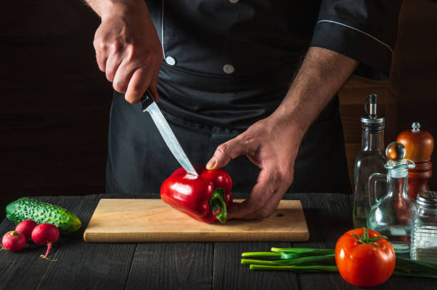 istock A professional chef is cutting red peppers for salad on a restaurant kitchen table. Vegetable diet or snack idea 1475512441