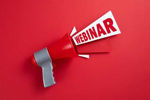Red megaphone with colored papers and webinar text on red background