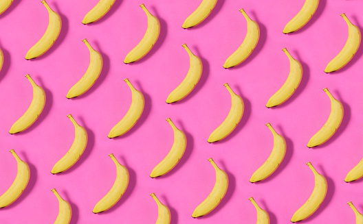 Bananas in a row on pink background