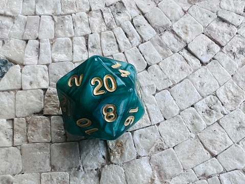 D20 green role playing dice on mosaic table