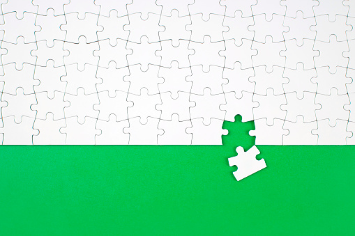 High angle view of jigsaw piece and on green background with copy space