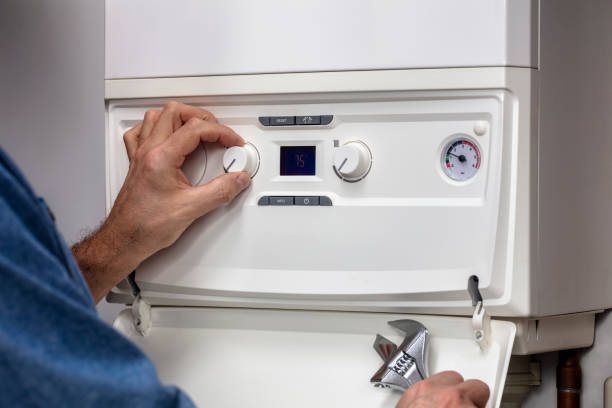 Plumber technician servicing or repairing home heating system boiler