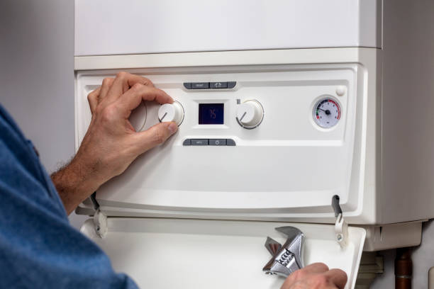 Plumber technician servicing or repairing home heating system boiler stock photo