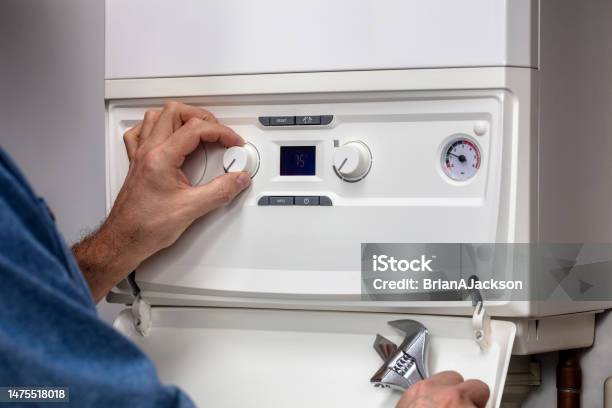 Plumber Technician Servicing Or Repairing Home Heating System Boiler Stock Photo - Download Image Now