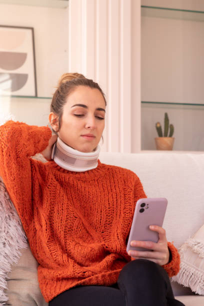 istock Discontent woman touching splint on neck while having video chat with doctor on smartphone during treatment 1475525575