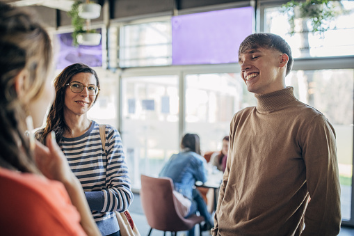 Group of people, male and female friends together indoors in a cafe.