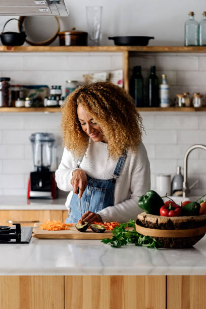 istock Woman preparing food in kitchen. 1475529737