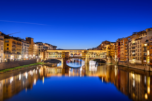Florence, Italy at the Ponte Vecchio Bridge crossing the Arno River at twilight.