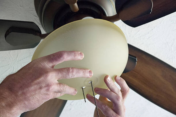 Installing Fan Male hands shown installing a ceiling fan ceiling fan stock pictures, royalty-free photos & images