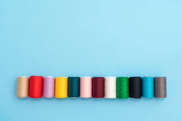 istock Row of colored spools with sewing threads close up and place for inscription 1475539238