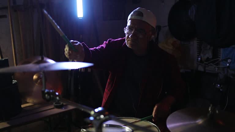 One man, an older man plays drums, remembering his younger days playing drums in the garage. concept of aging, retirement days