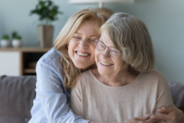istock Loving middle-aged daughter cuddles her smiling elderly mom, closeup 1475545263