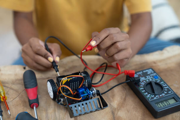 istock Young female  learning toy robotics technology online with computer tablet. Young woman building robotic toy car in classroom. Education and technology concept 1475548382