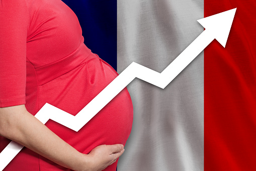 Pregnant woman on flag of France background. Birth rate up