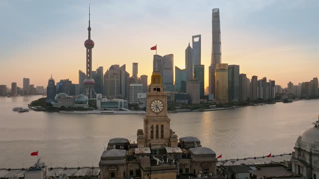 Aerial footage of The Bund and Lujiazui in Shanghai China at sunrise.The old customs house as a foreground.