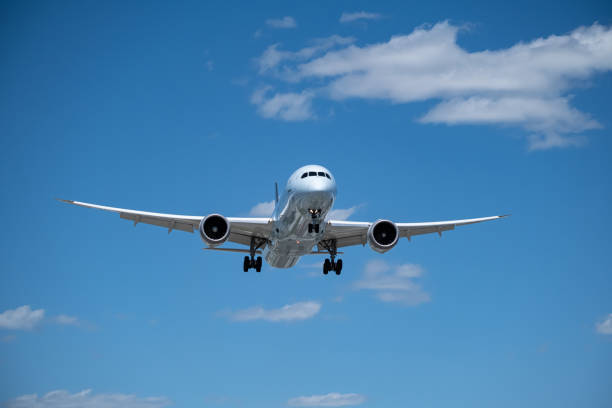 air canada commercial airplane on final approach to land on a blue sky with few clouds stock photo. - boeing 787 air vehicle travel business travel imagens e fotografias de stock