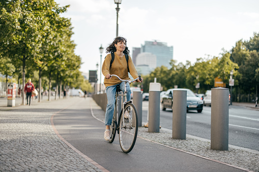 Man Cycling Through Park Towards Camera During Summer