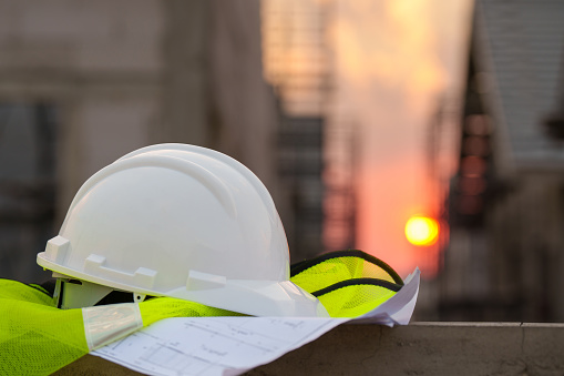 white safety helmet in construction site and construction site worker background