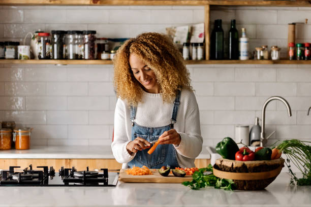 femme préparant la nourriture dans la cuisine. - fruit women beautiful food photos et images de collection