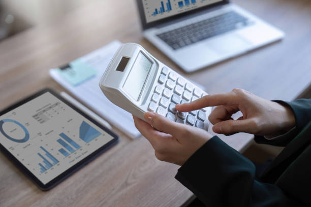istock female employee working on a laptop computer in a modern office. Make an account analysis report. real estate investment information financial and tax system concepts 1475561918