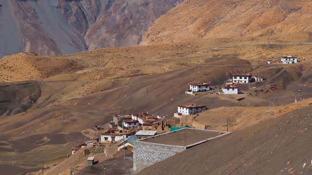 4K shot of houses on the side of the mountain at Hikkim village near Kaza in Spiti Valley, Himachal Pradesh, India. Traditional houses with dried grass on top at Spiti. Houses on side of mountain.