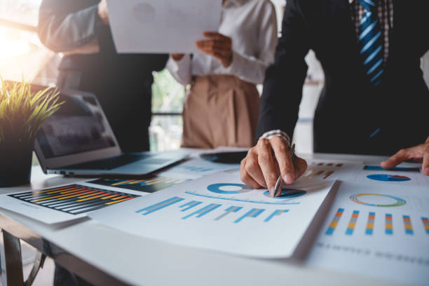istock Businesspeople pointing to graphs and charts, thinking and analyzing various data in reports market growth to plan new sales strategies to increase productivity. 1475565080