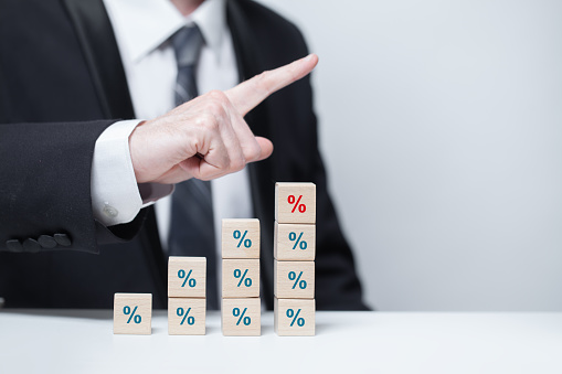 Wooden blocks with green and red percent icons, business percentage banks concept, businessman pointing up